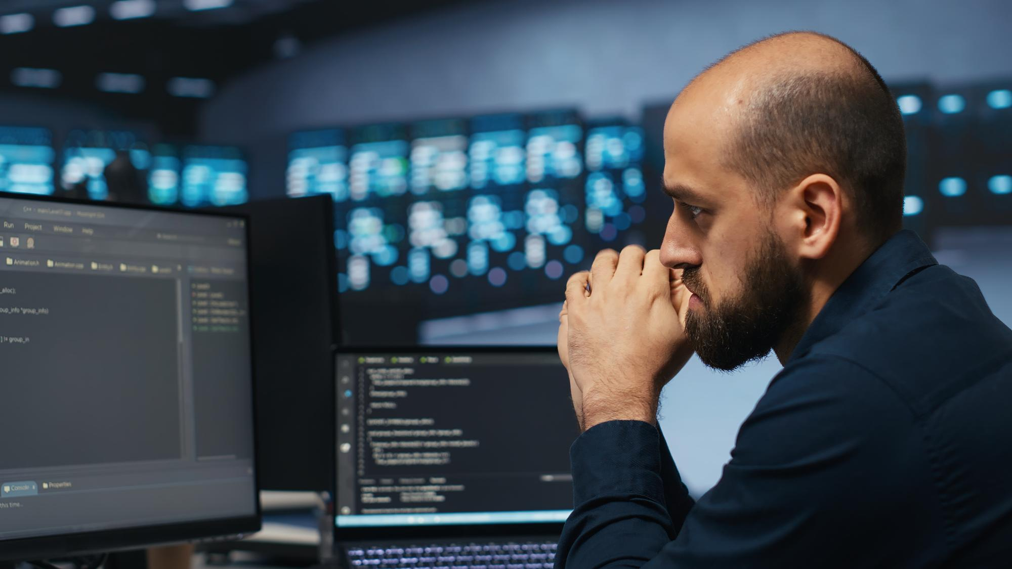 Cloud security engineer analyzing logs and cloud infrastructure data on multiple monitors in a modern security operations environment